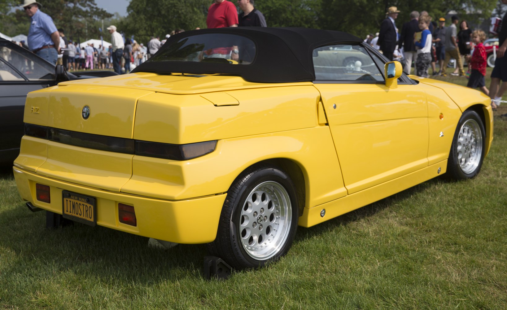 Yellow convertible sports car rear and side view with boxy tail design