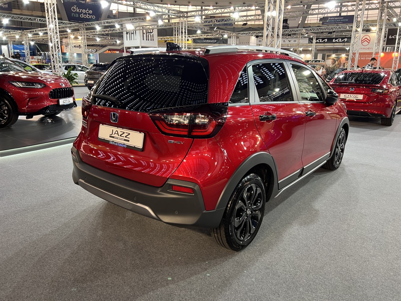 Rear view of red hybrid hatchback with black trim and modern taillights