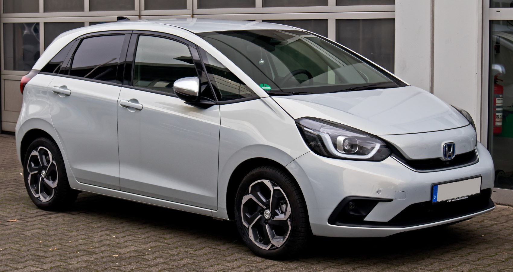 Compact hatchback front side view with modern headlights and alloy wheels