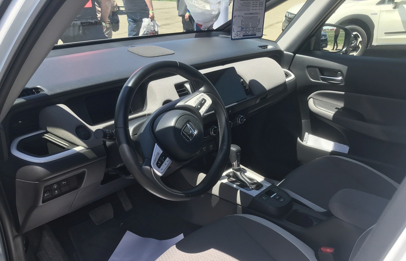Car interior with dashboard, steering wheel, seats, and gear shifter