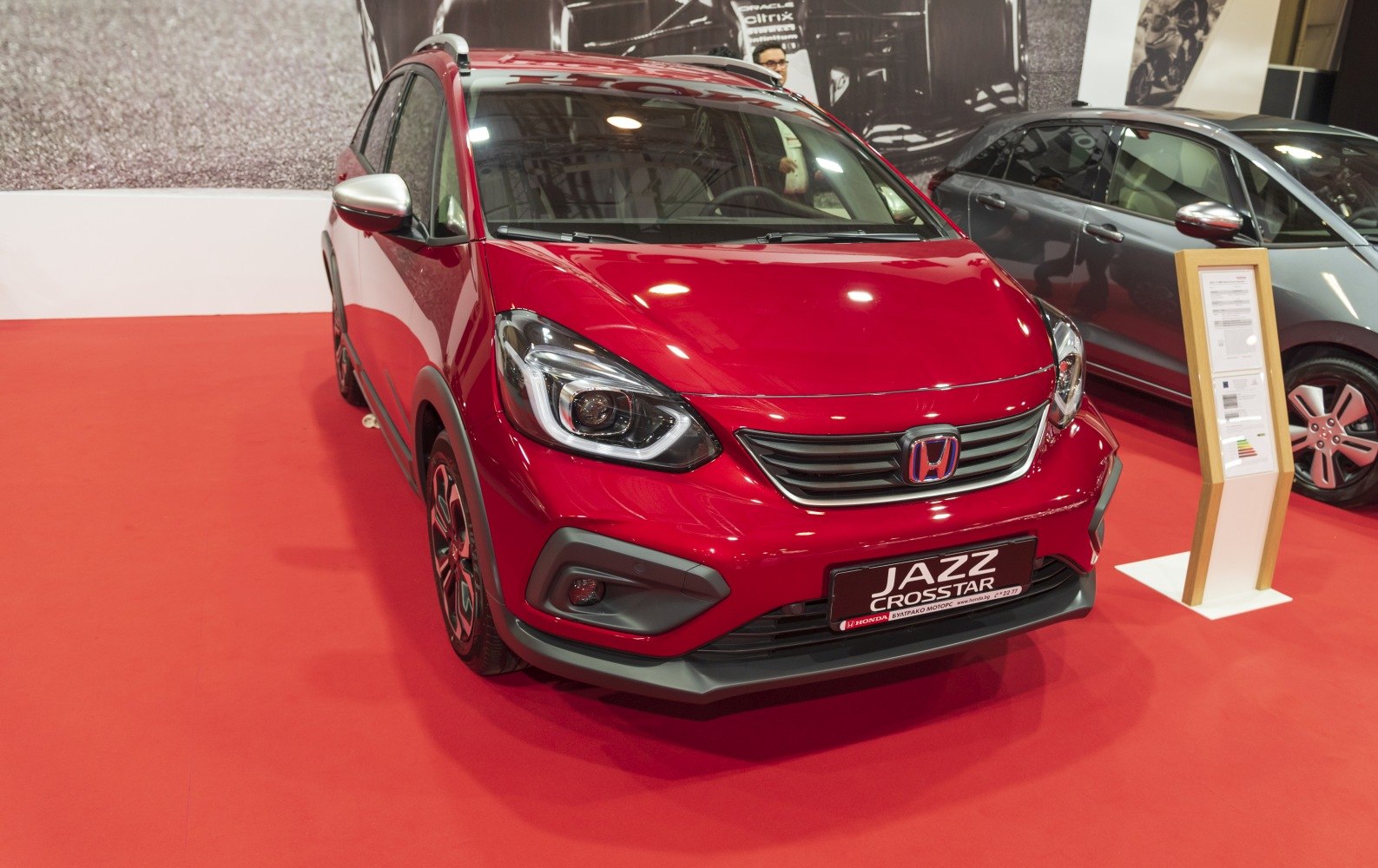 Red compact hatchback showcasing front grille and headlights