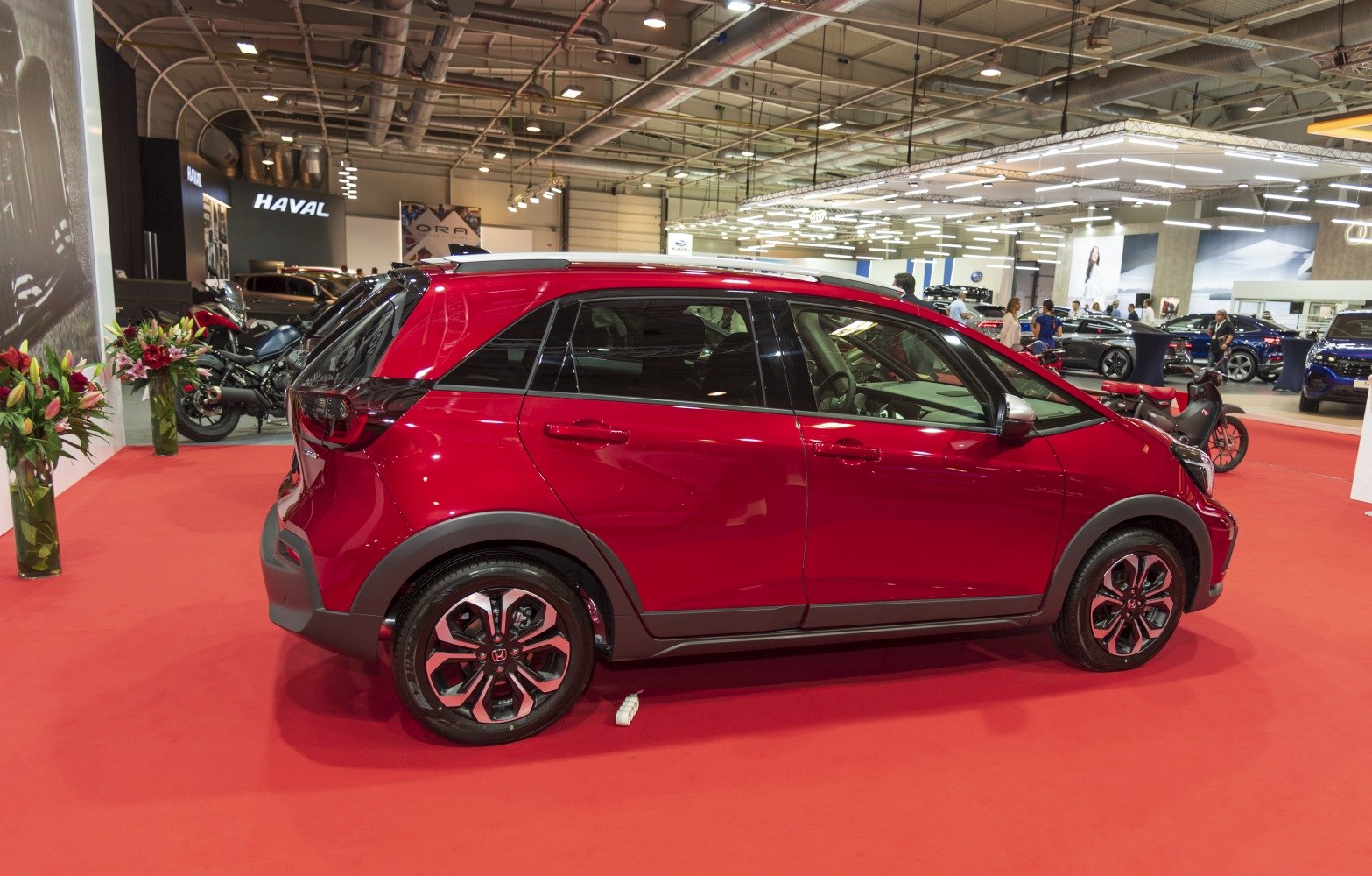 Red compact hatchback side view with black roof and alloy wheels