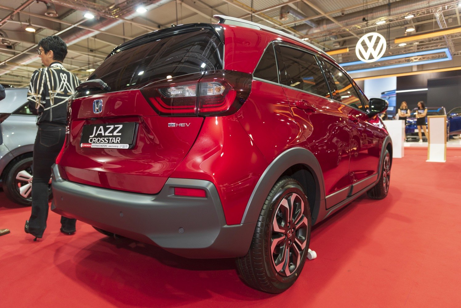 Rear view of a red compact hybrid vehicle with modern taillights and alloy wheels.