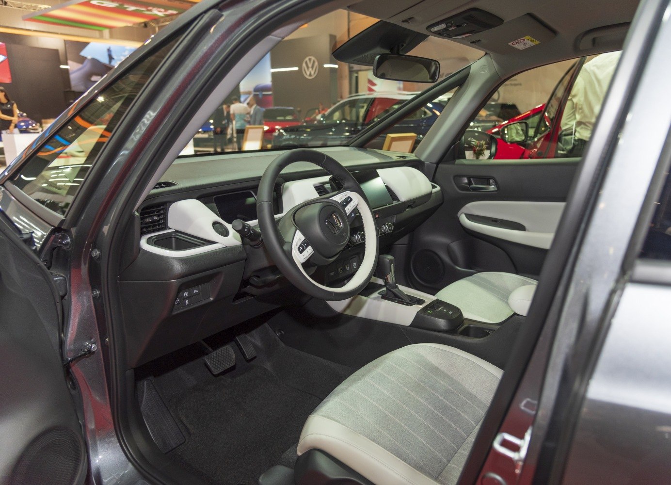 Modern car interior with white accented steering wheel and minimalist dashboard