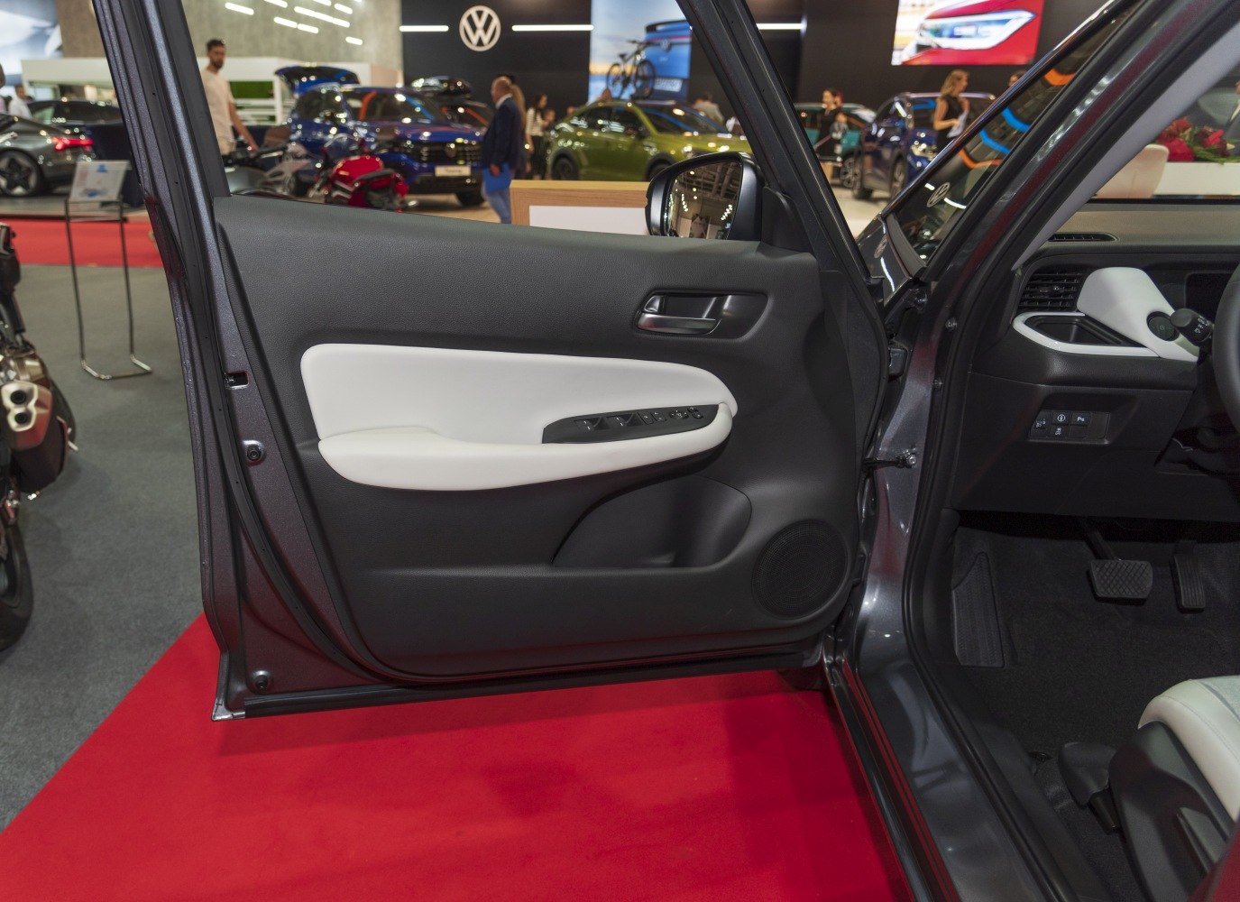 Car door interior panel with control buttons and driver footwell with pedals