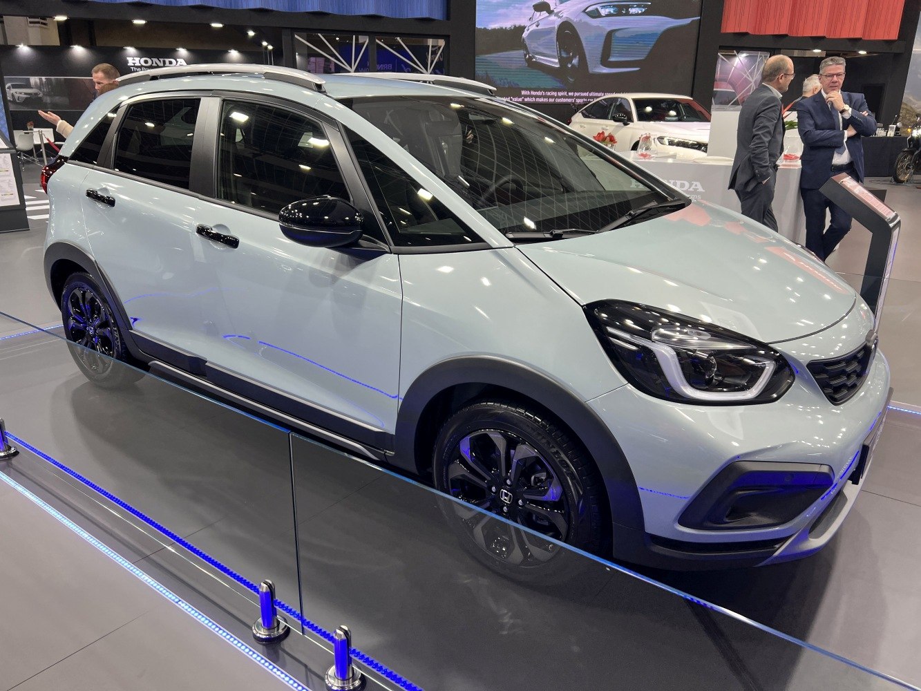 Compact hatchback with black wheels, roof rails, and tinted windows.