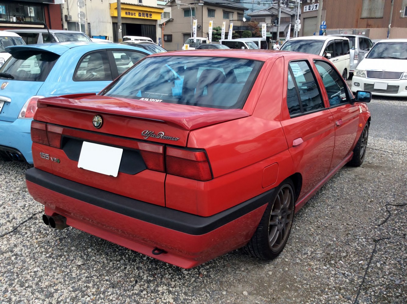 Red sedan rear view with spoiler and dual exhaust pipes