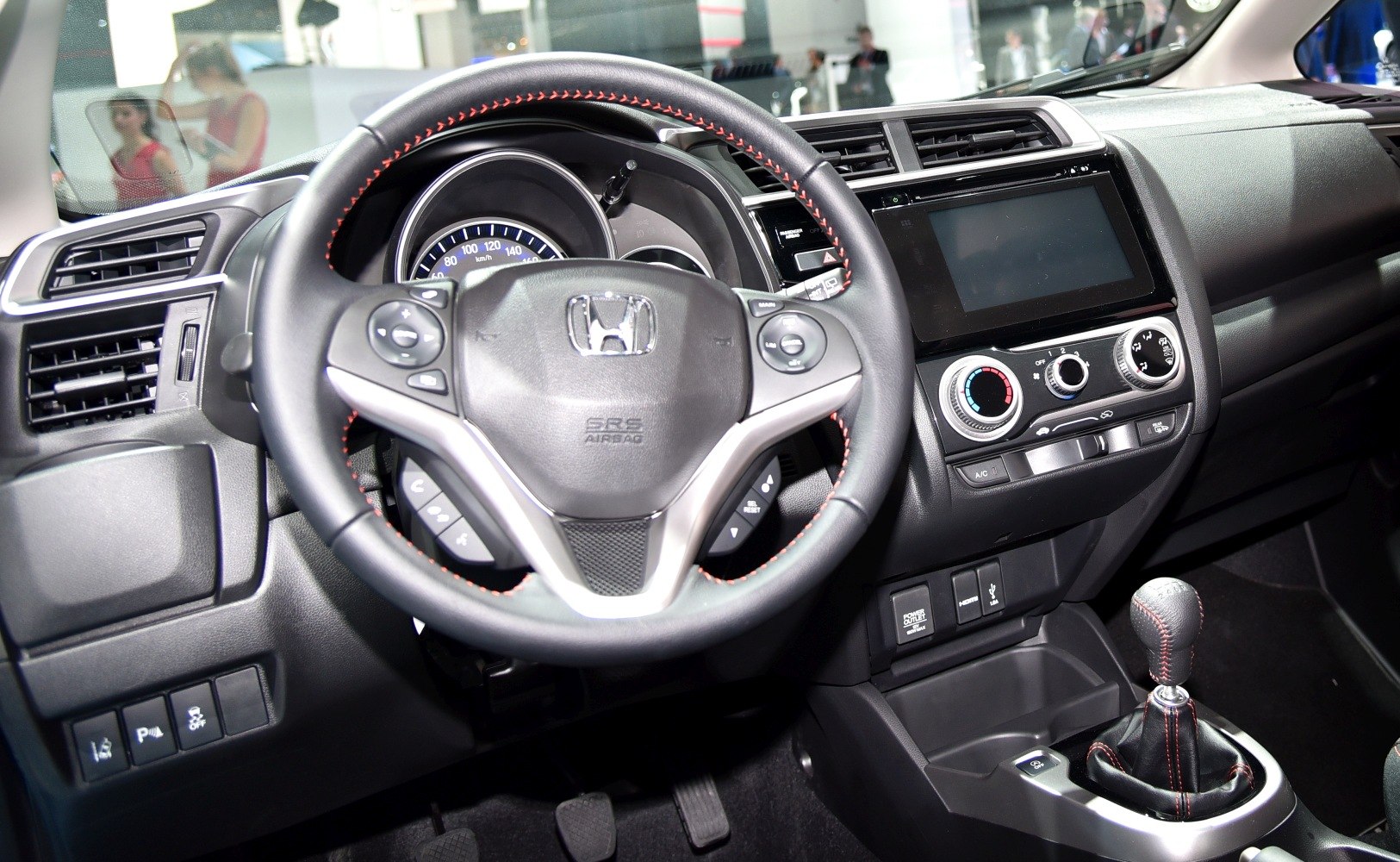 Steering wheel with controls, manual gear stick, and modern dashboard layout