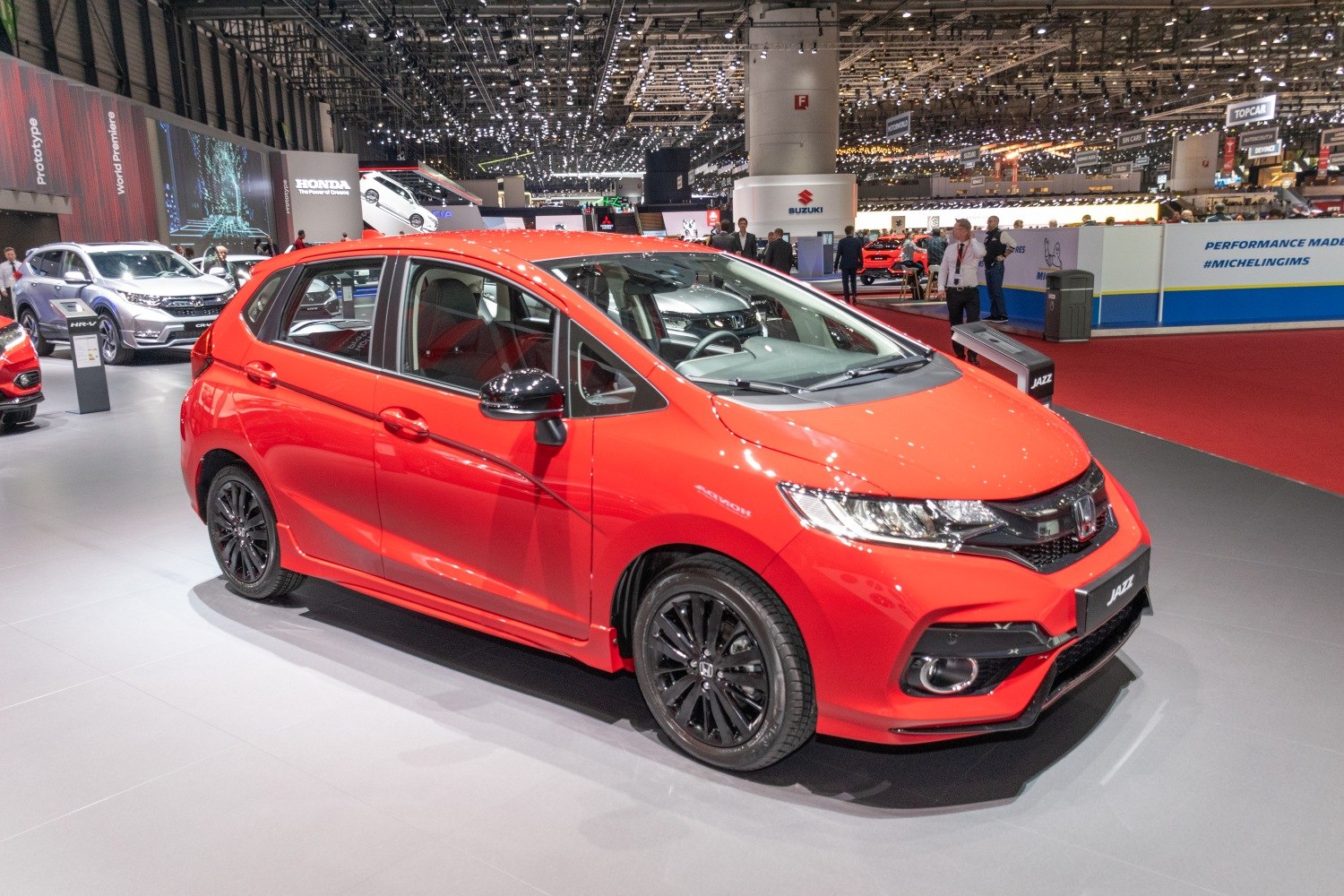 Red hatchback with black alloy wheels and LED headlights