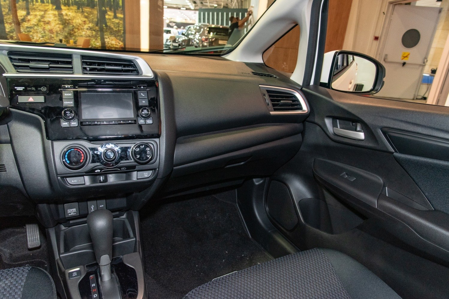 Compact car interior with dashboard, gear shift, and climate controls