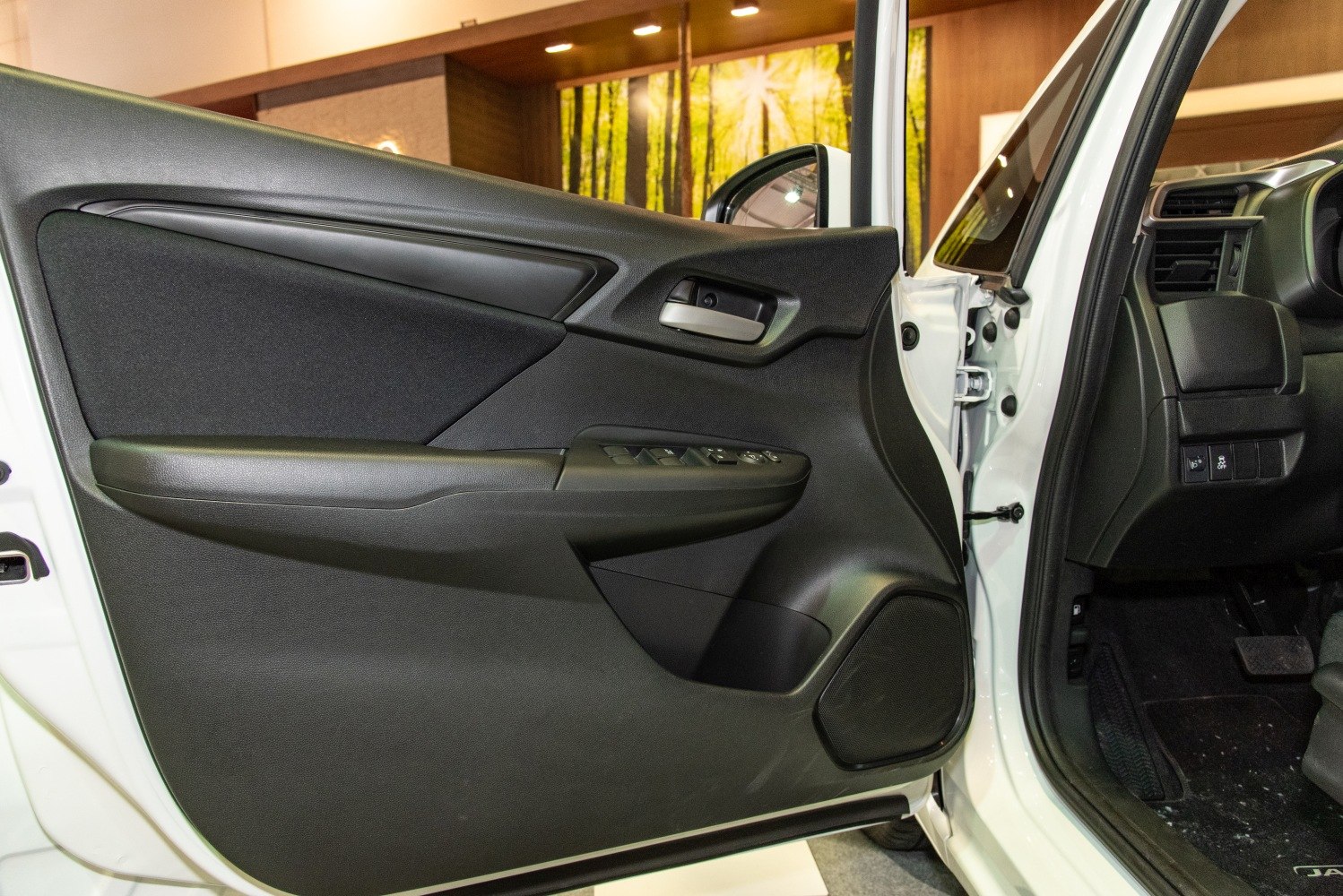 Black interior door panel with window controls and handle