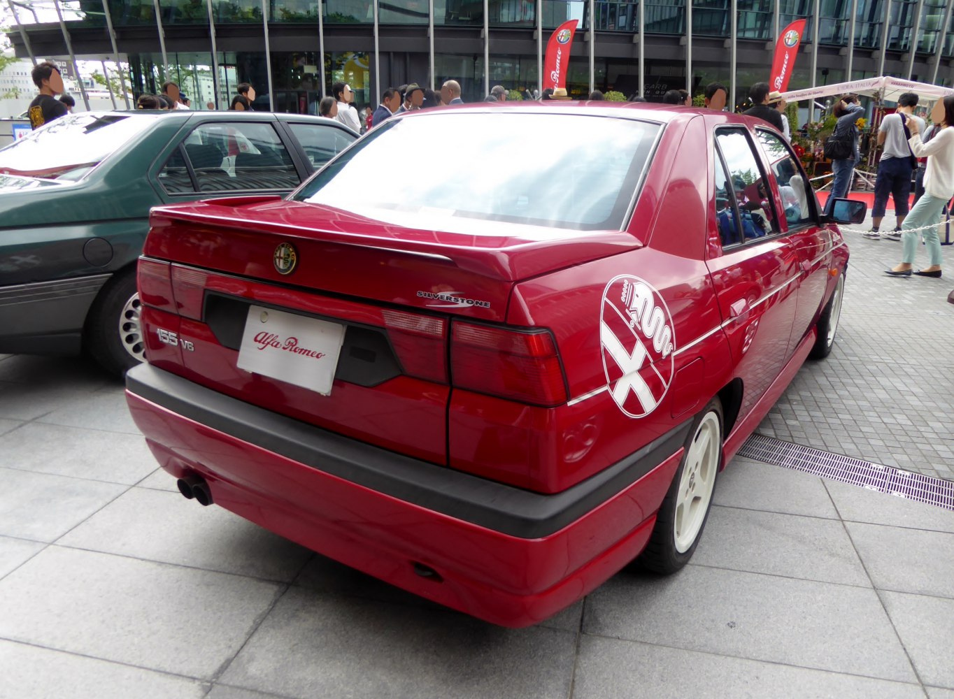 Rear view of red sedan with spoiler and unique badge