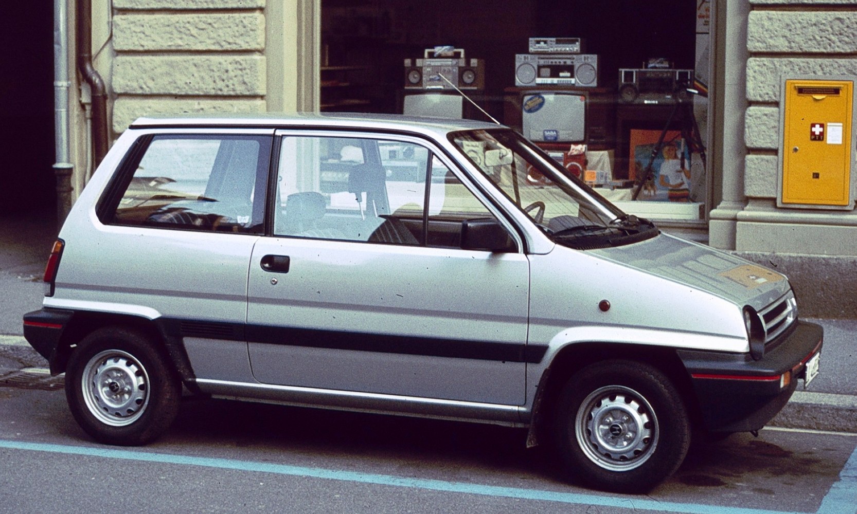 Side view of a compact three-door hatchback with distinctive black trim