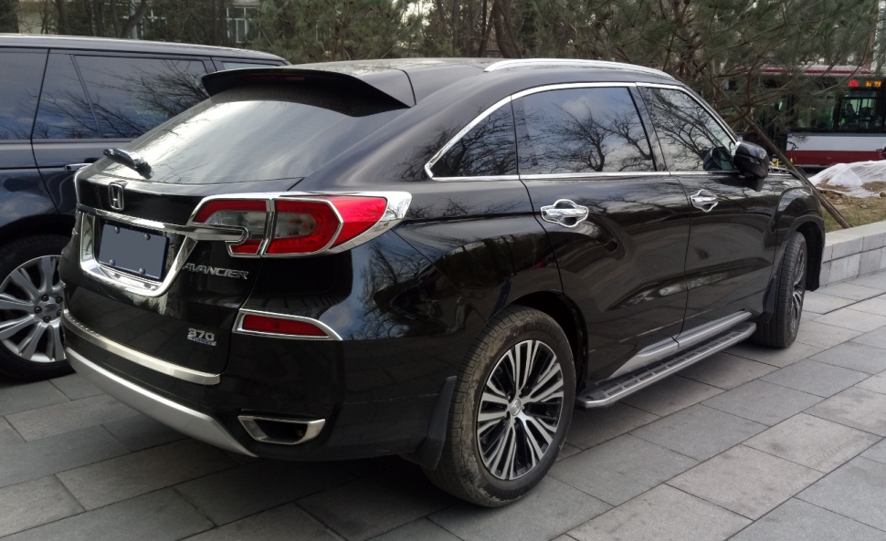 Rear and side profile of an SUV with alloy wheels and roof spoiler