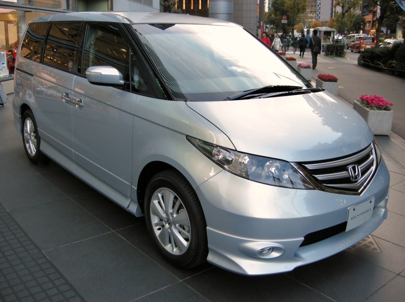 Silver minivan front side view with sleek headlights and aerodynamic styling