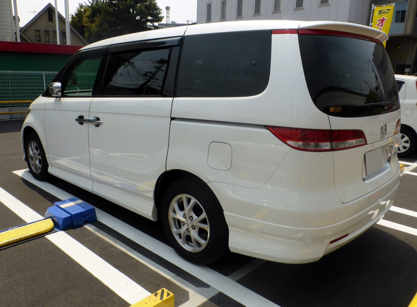 Rear side profile of white MPV with tinted windows and alloy wheels