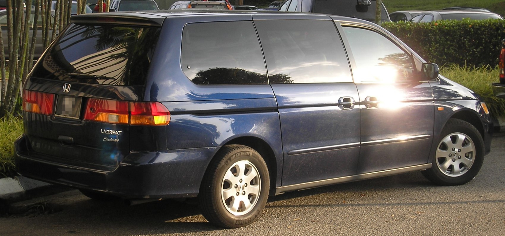 Side rear view of blue minivan with tinted windows and rear sliding door