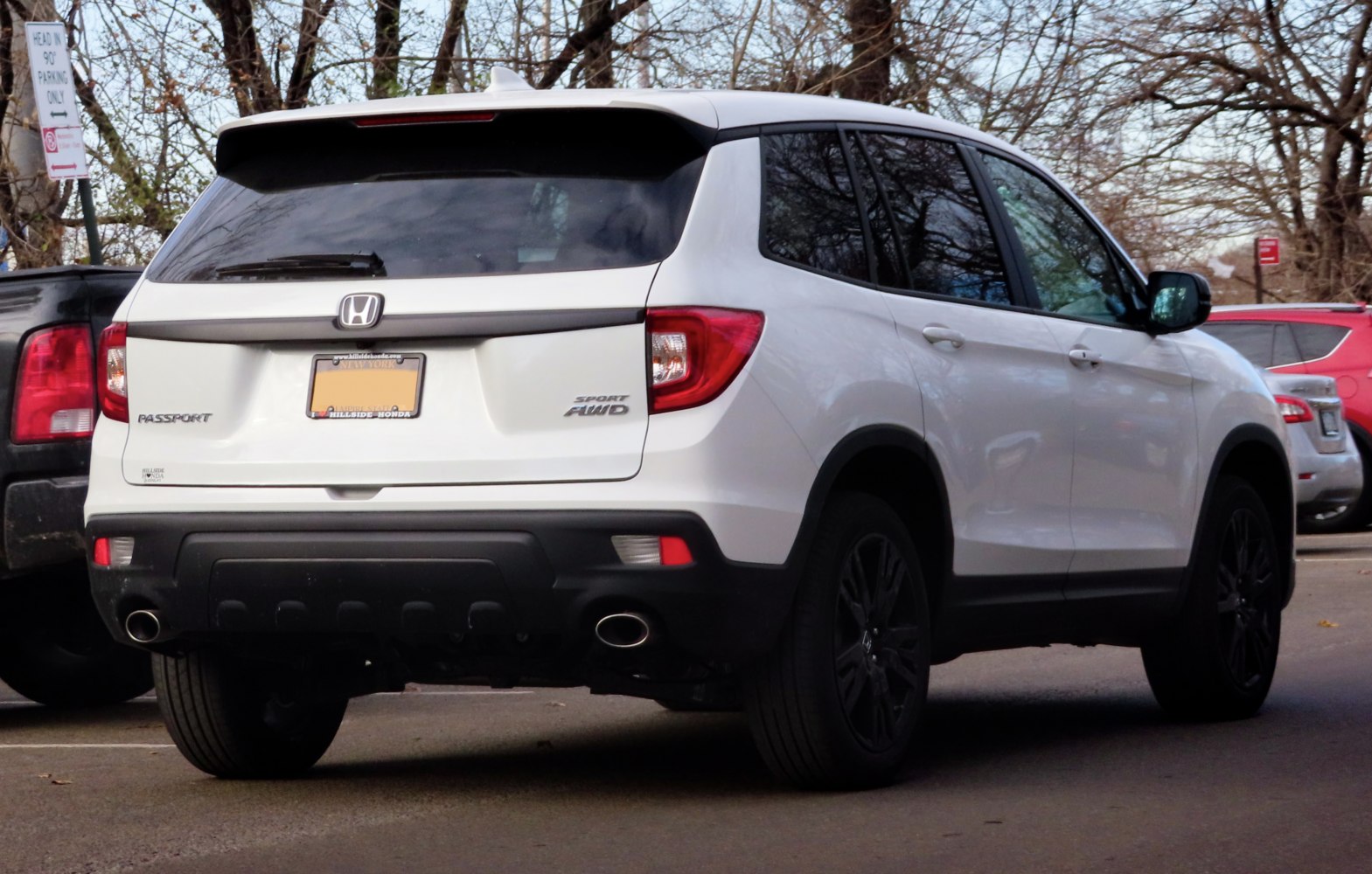 Rear view of white SUV with dual exhaust and black trim.