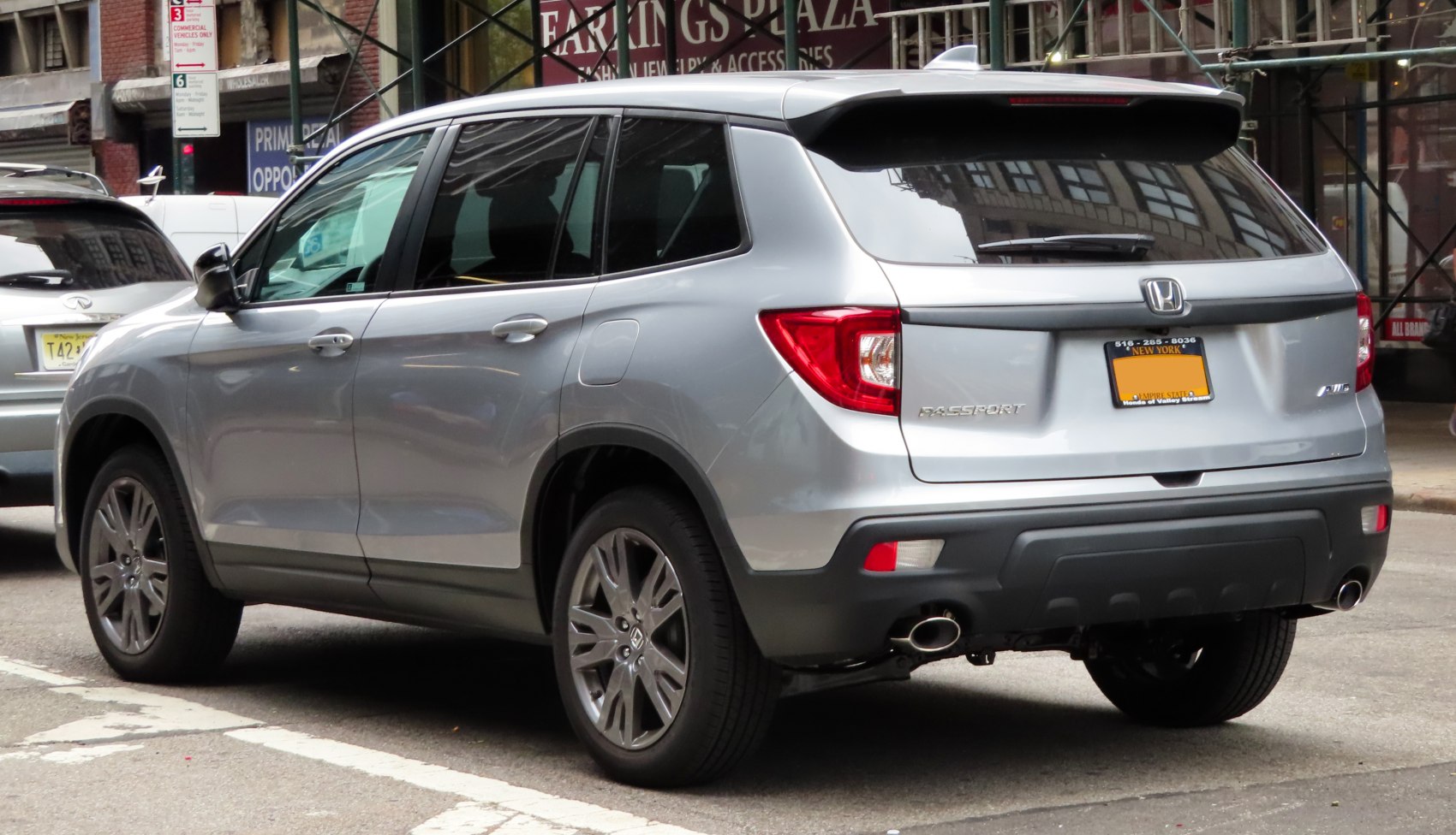 Silver SUV rear side with dual exhausts and tinted windows