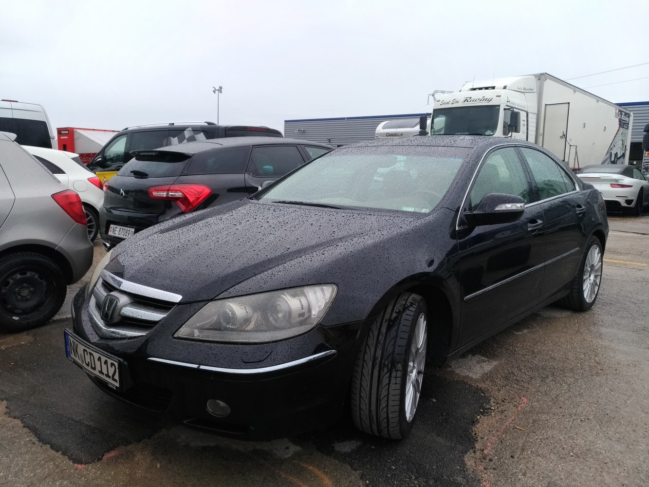 Front side view of wet luxury sedan with alloy wheels