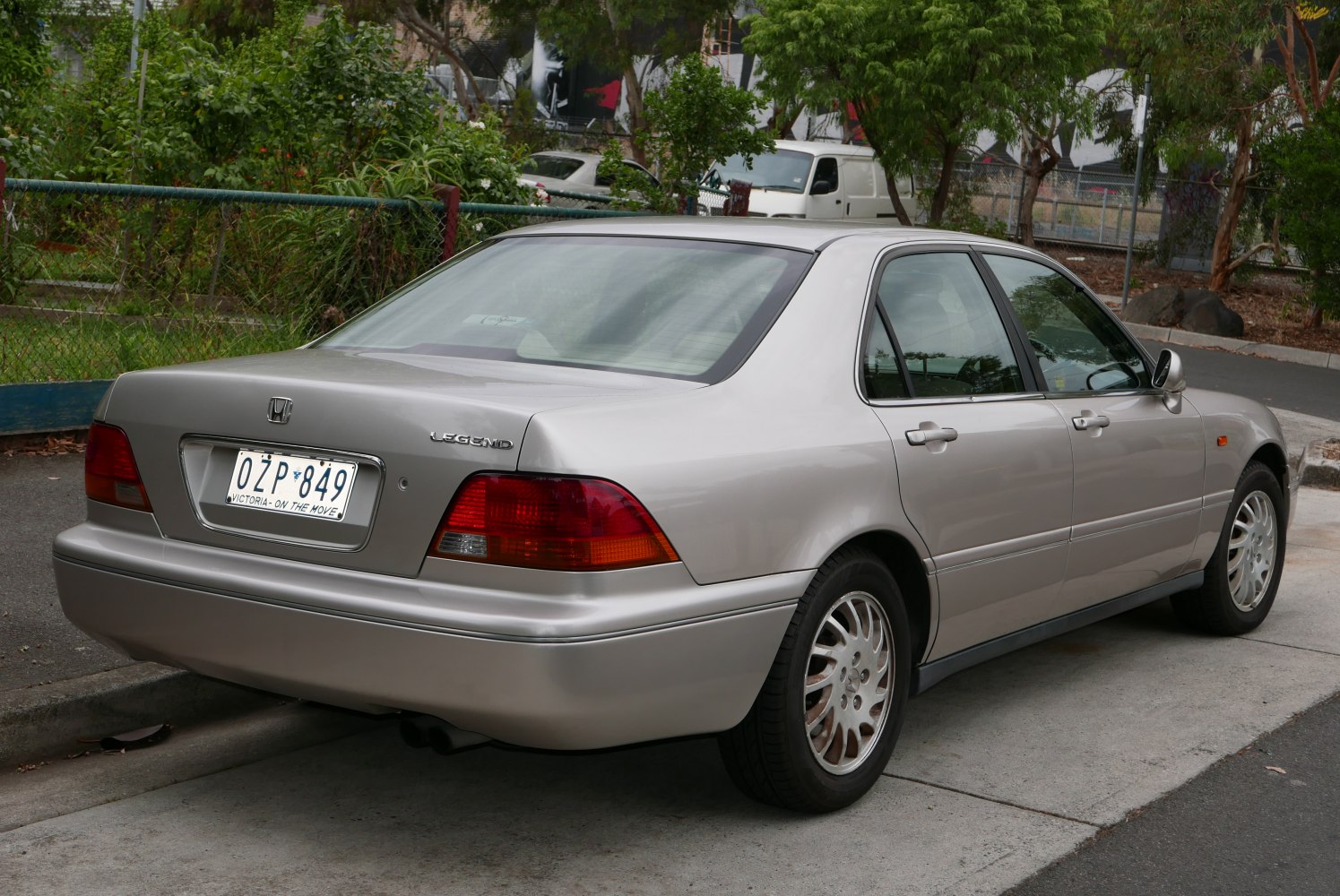 Rear and side view of an executive sedan with multi-spoke alloy wheels and distinctive rear lamps.