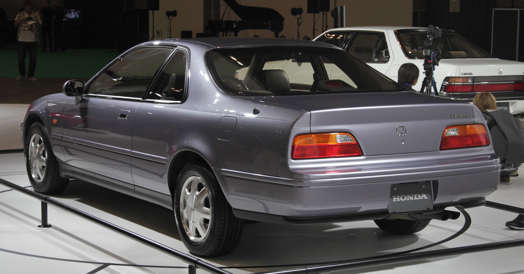 Rear view of a classic coupe highlighting tail lights and smooth body lines.
