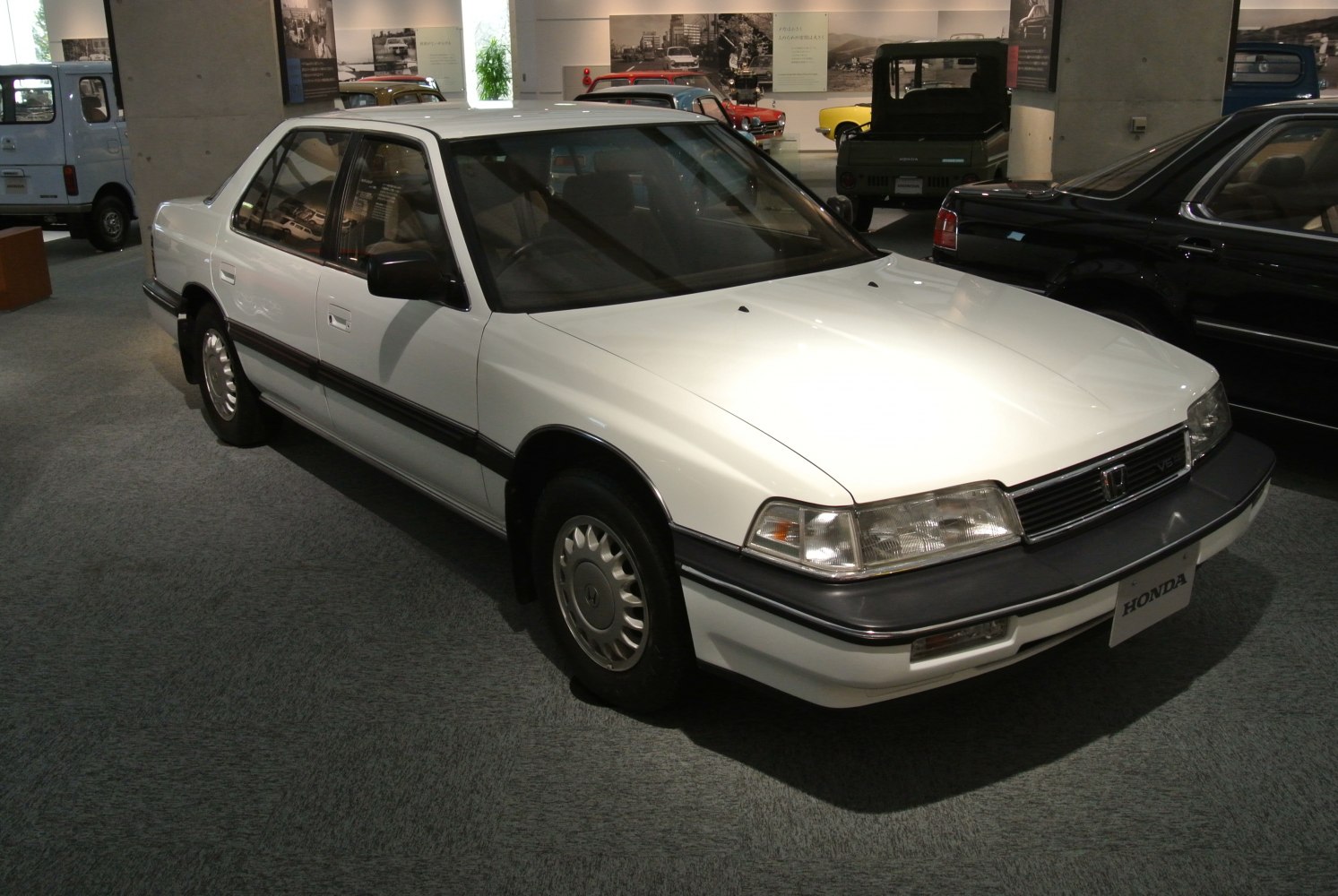 White classic sedan showing front-side view with detailed headlights