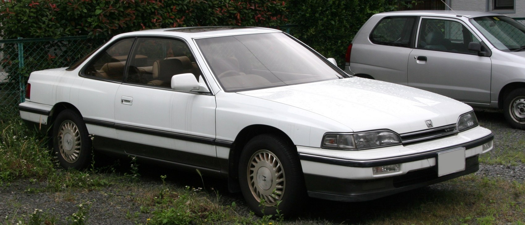 White two-door luxury coupe with sleek, classic 1980s design
