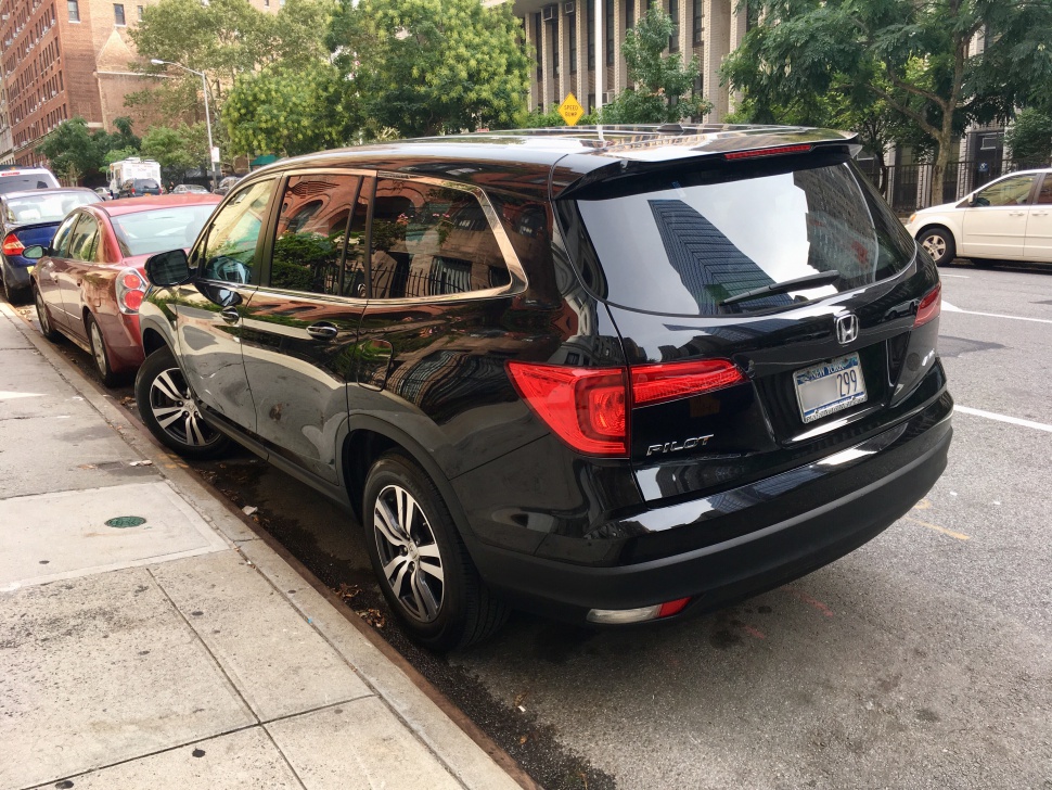 Rear side of a black mid-size SUV with taillights and alloy wheels