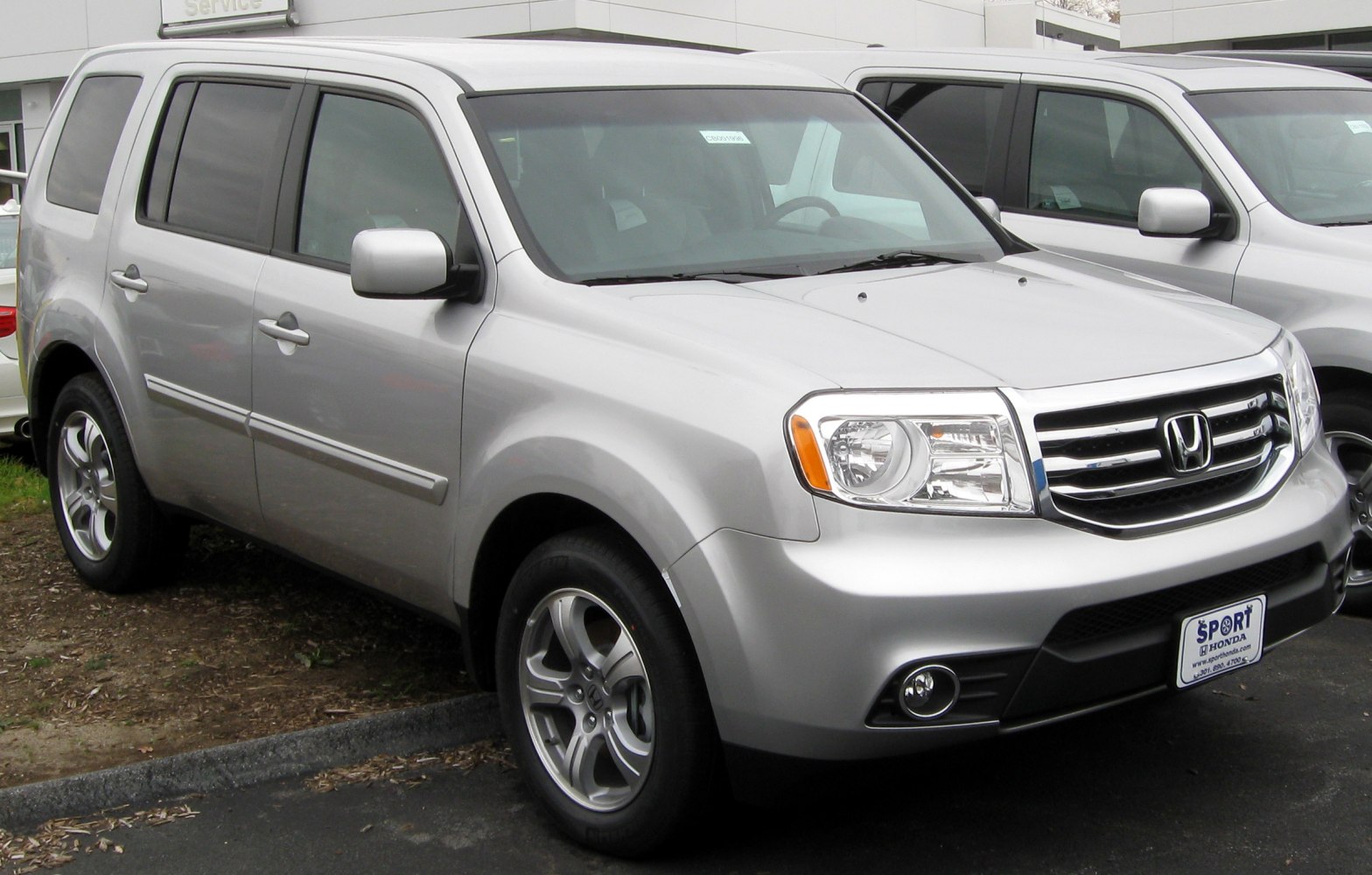 Silver mid-size SUV front side, headlights, grille, wheels