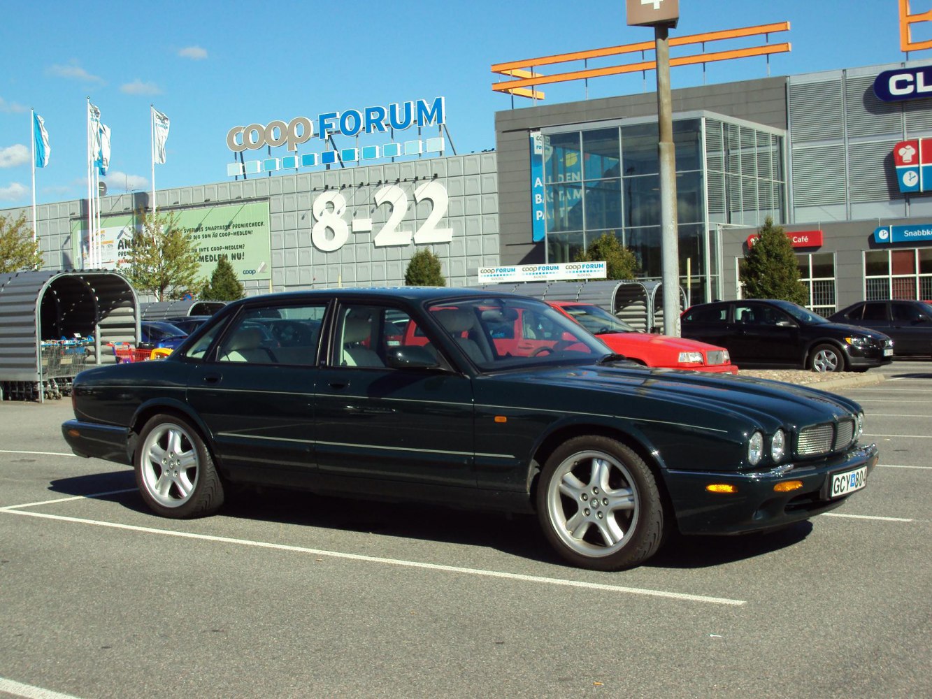 Side profile of luxury sedan with quad round headlights and 5-spoke alloy wheels.