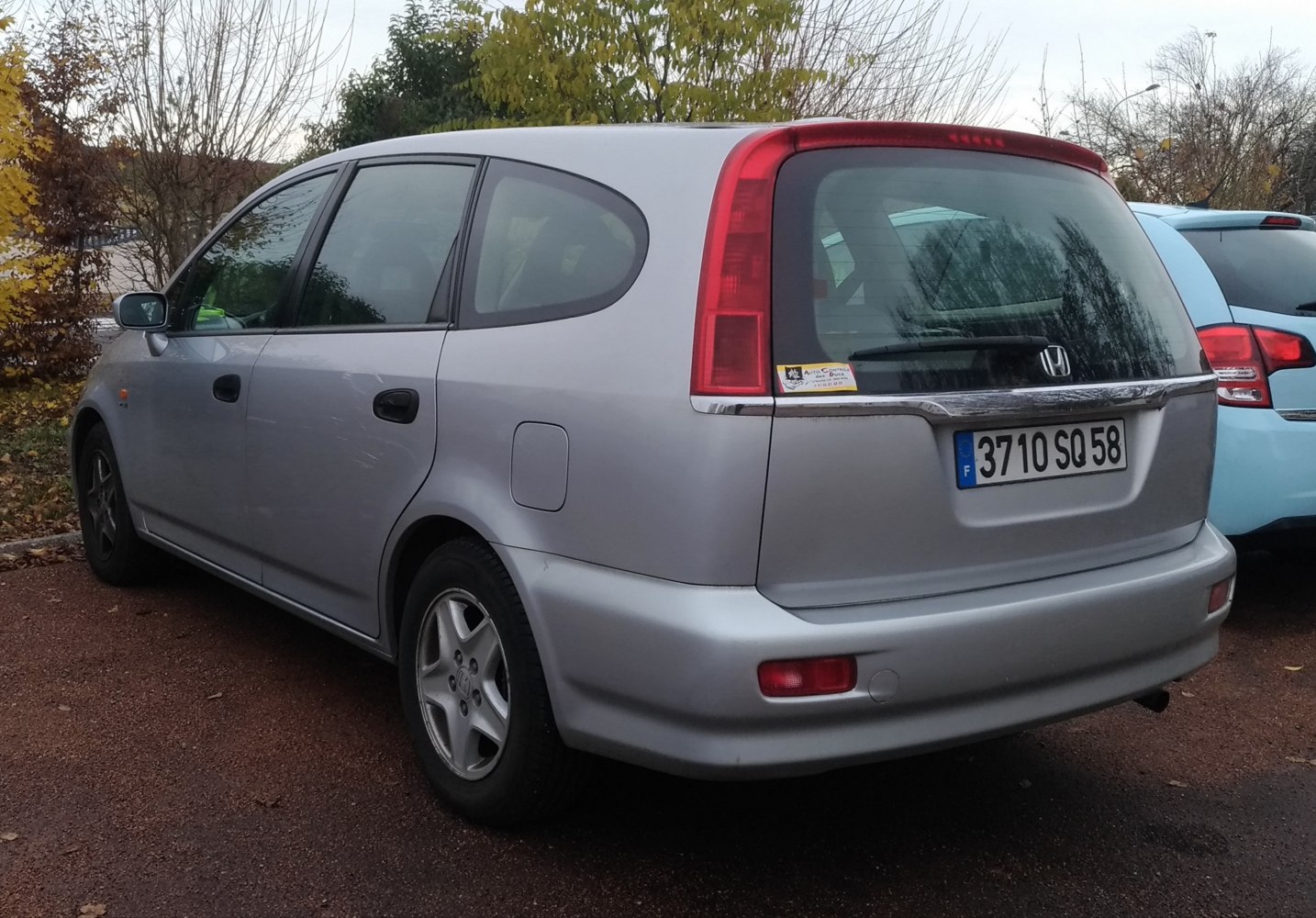 Rear and side view of silver vehicle with vertical tail lights and rear wiper