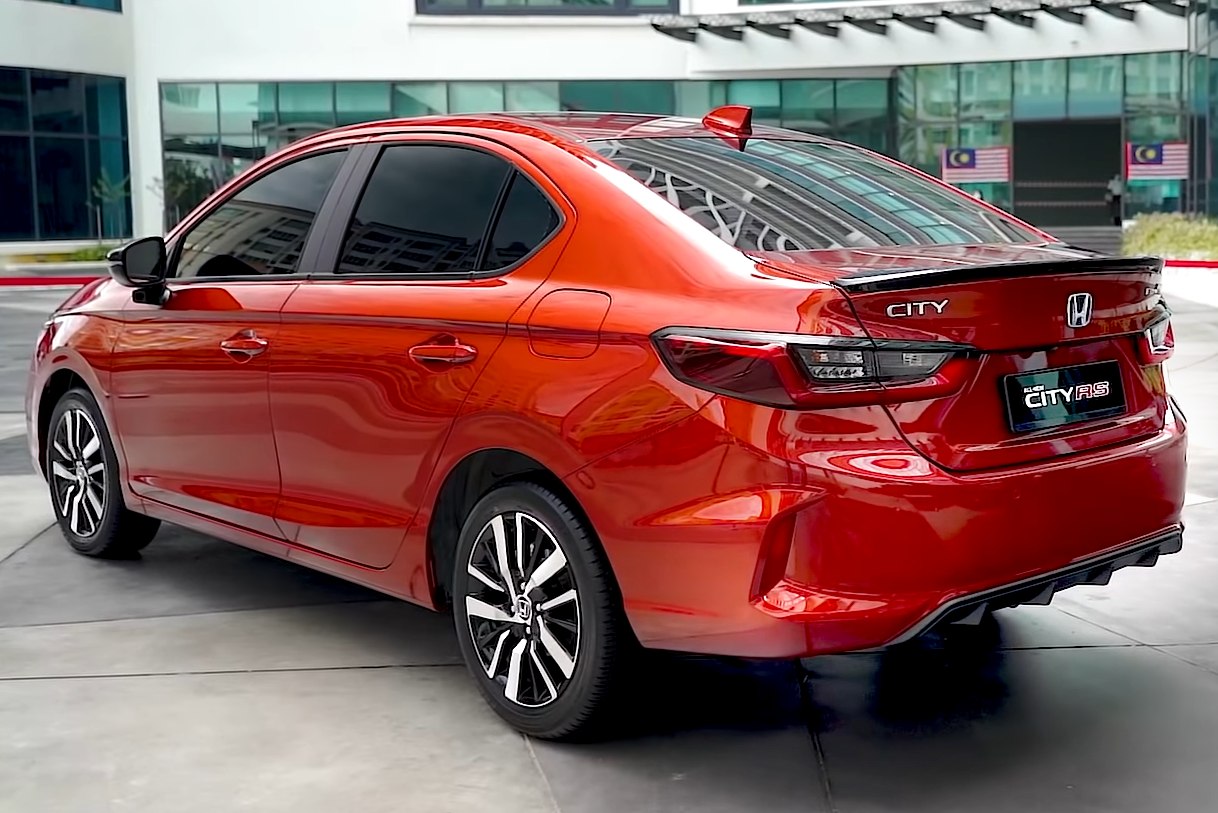 Rear and side view of a red sedan with alloy wheels and tinted windows