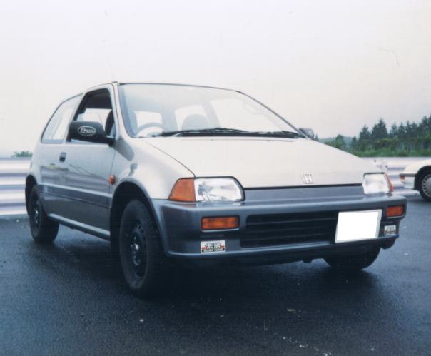 Compact hatchback front view with distinct headlamp and grille design.