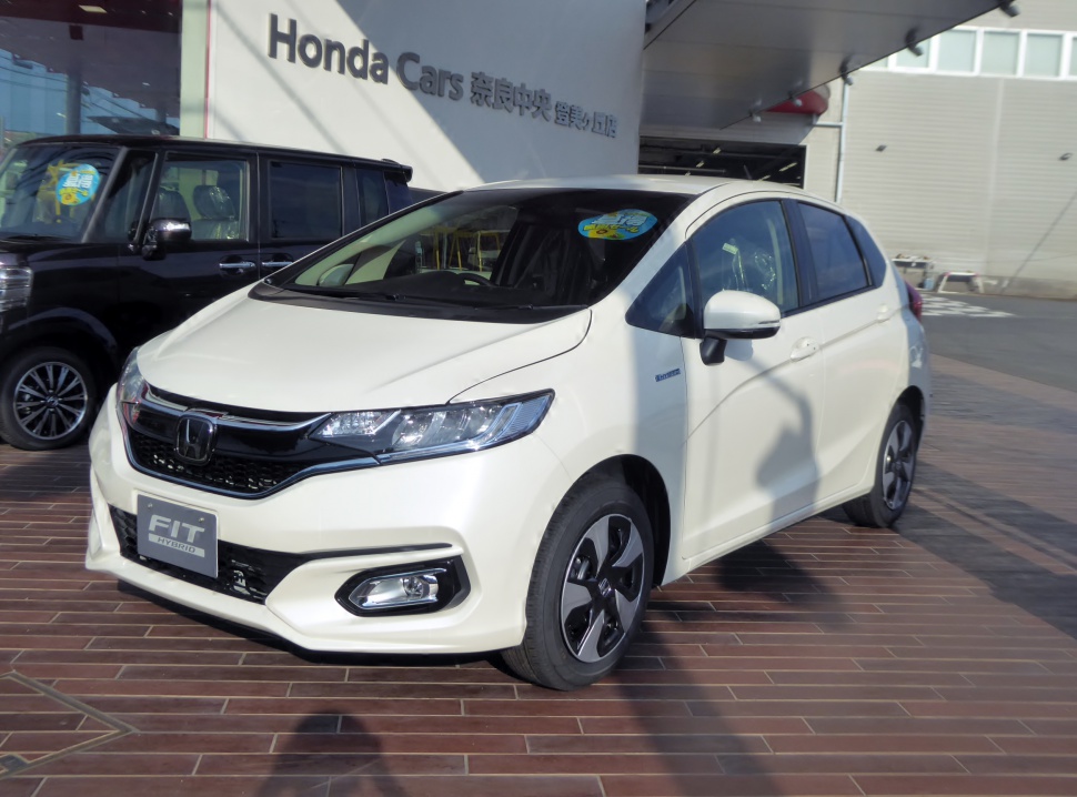 Front three-quarter view with headlights, grille, hybrid badge