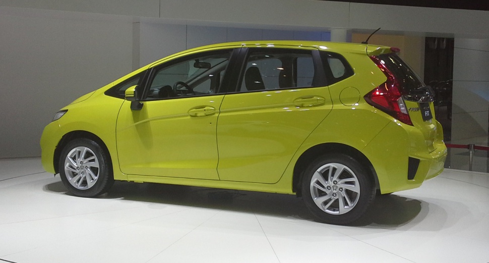 Side profile of a yellow compact hatchback with detailed door and wheel design