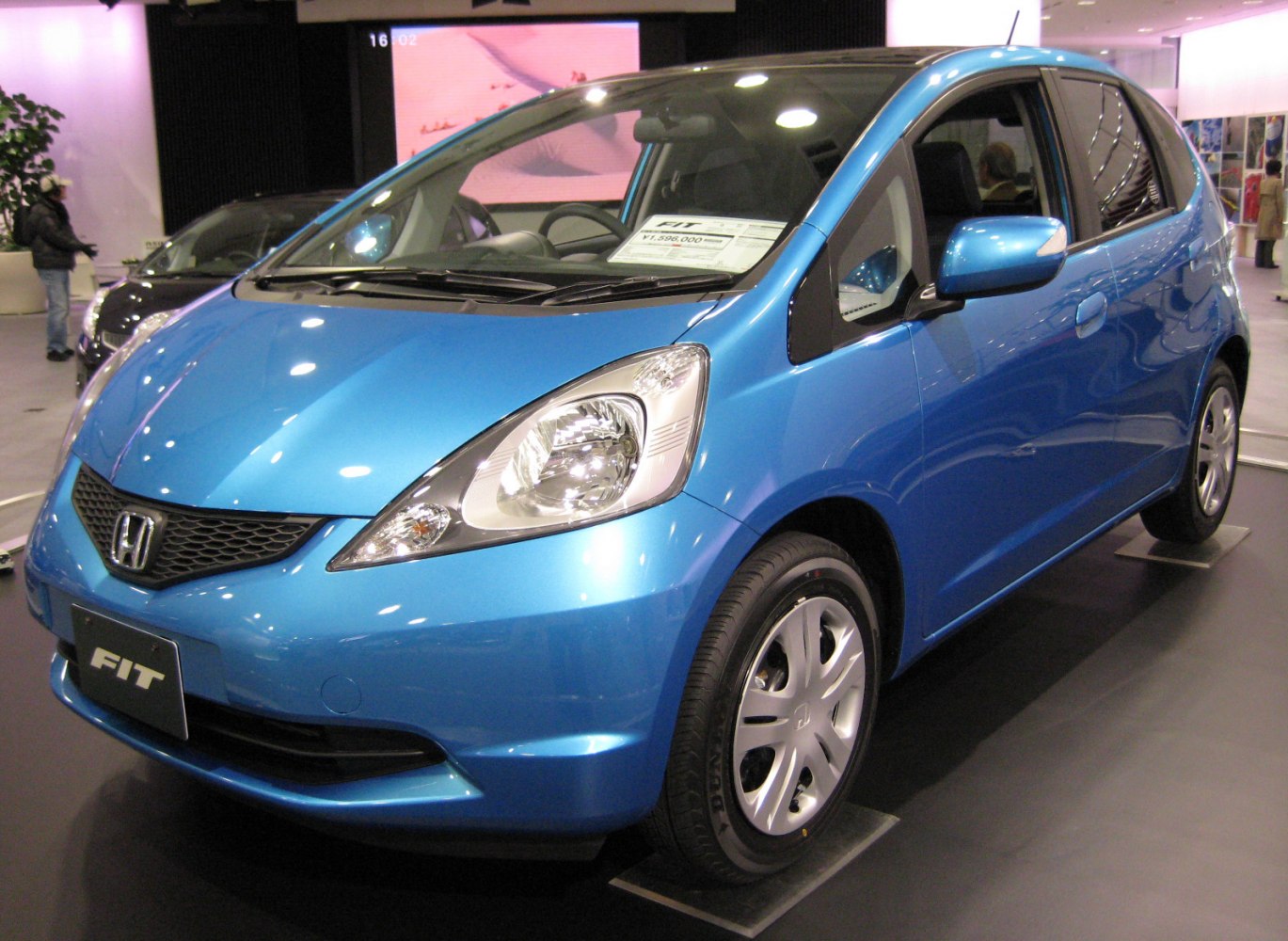 Compact blue hatchback front side with sleek headlights and alloy wheels