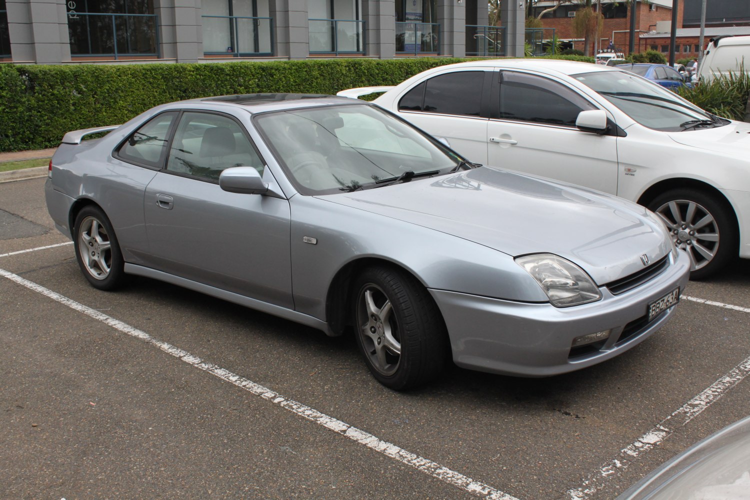 Silver two-door coupe with aerodynamic shape and distinctive headlights