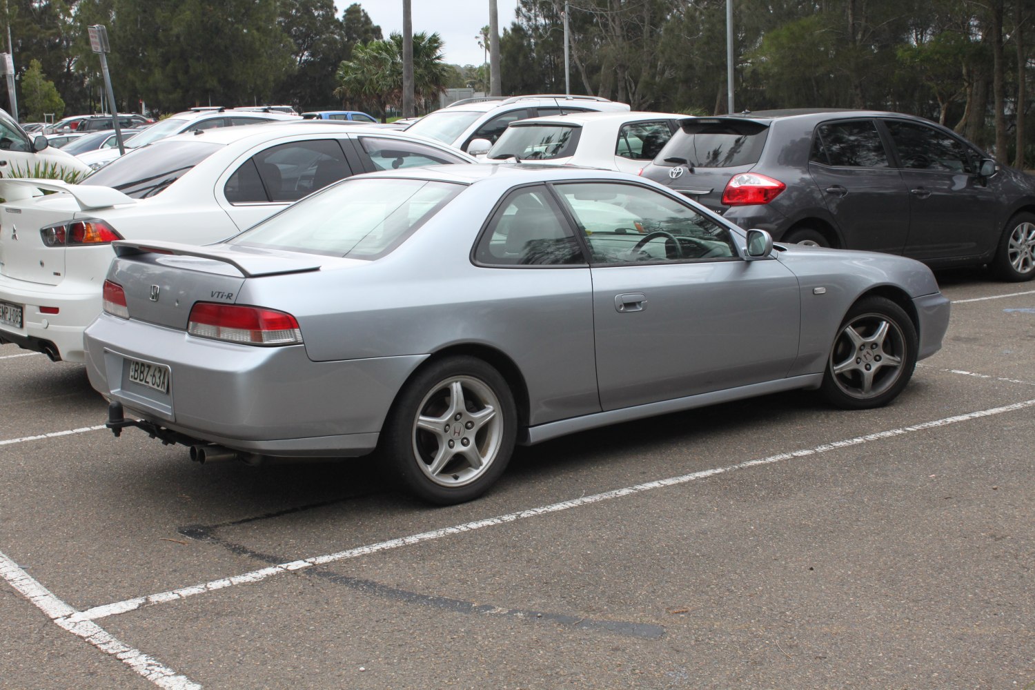 Silver coupe rear side profile with spoiler and alloy wheels