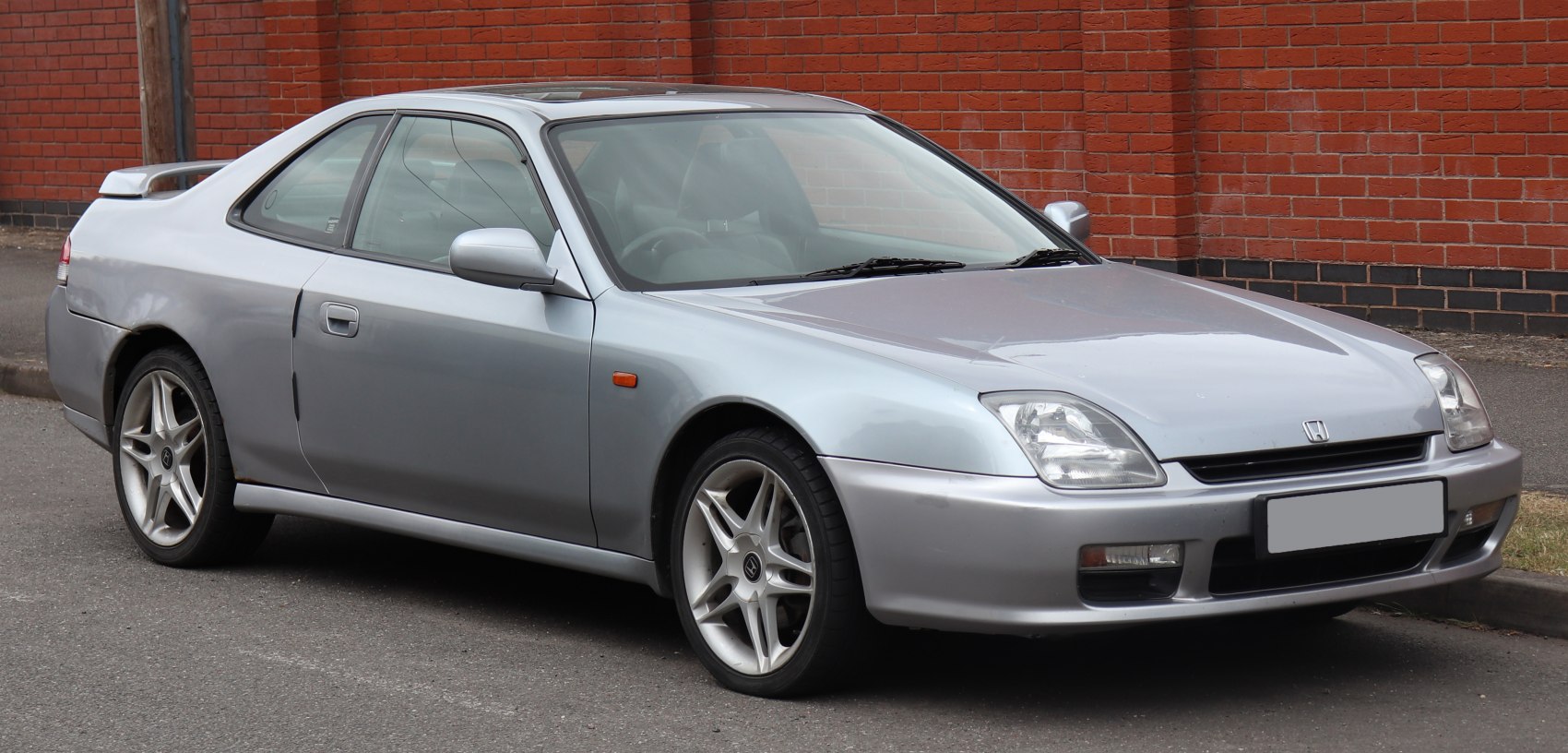 Silver two-door sports coupe with alloy wheels and sharp headlights