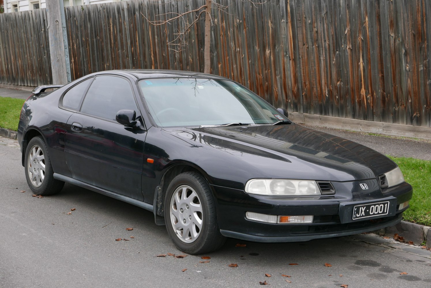 Front side view of a classic coupe with signature dual headlights and sporty design.
