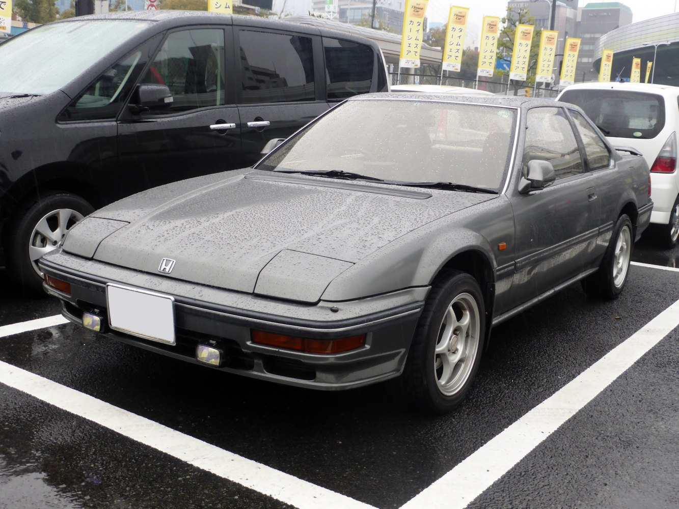 Sportscar with pop-up headlights and fog lights in wet parking