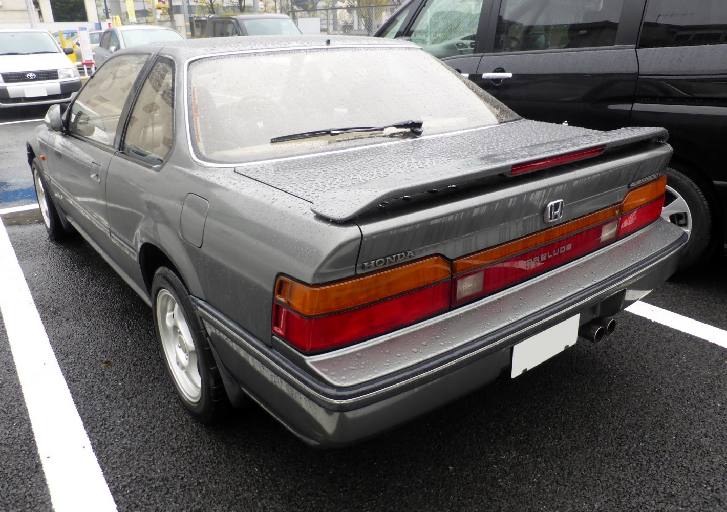 Rear view with spoiler and dual exhaust on a 1980s sports coupe