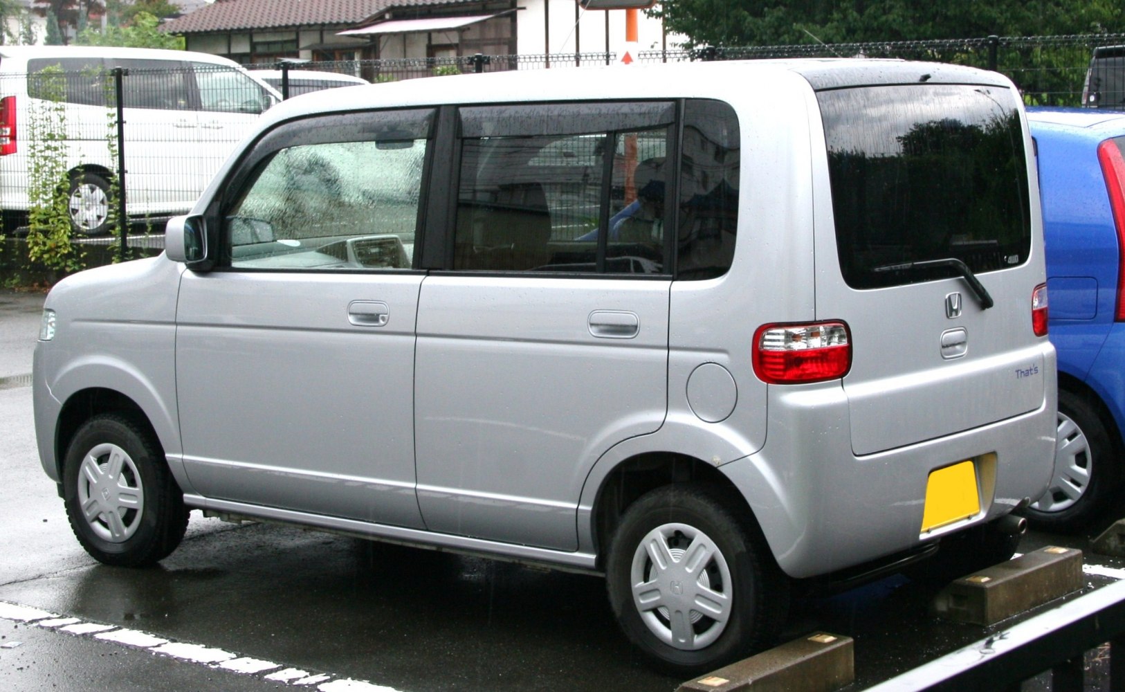 Boxy silver subcompact car with large windows, side and rear view