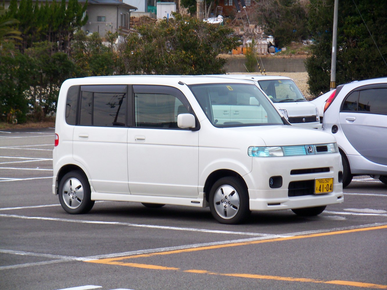 Compact white boxy minivan with distinctive front grille and side mirrors