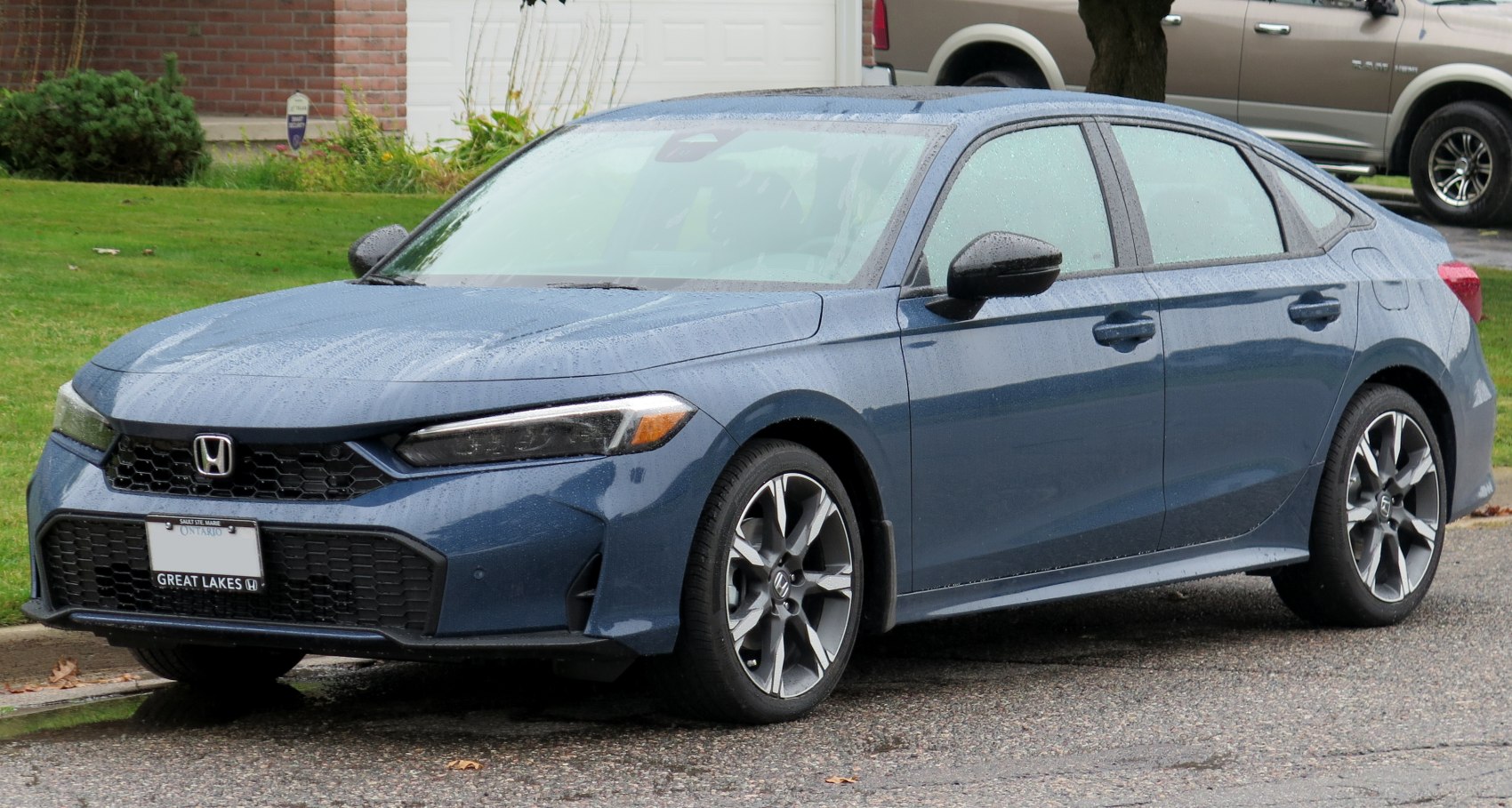 Front and side view of a blue sedan with sleek headlights and alloy wheels