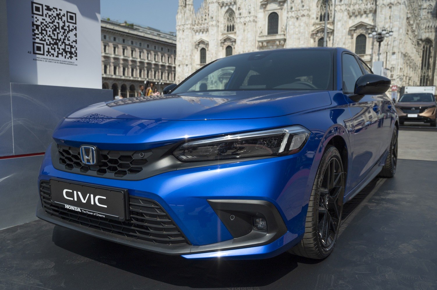 Front view of modern blue sedan with sleek headlights and honeycomb grille
