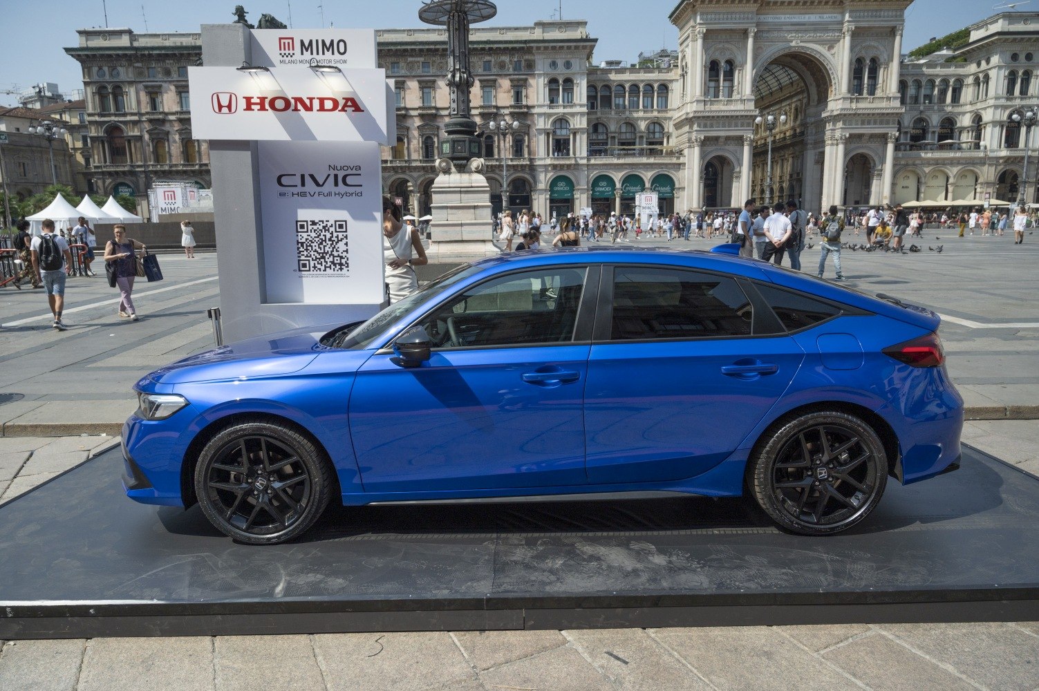Side profile of blue sedan with black alloy wheels and sleek lines