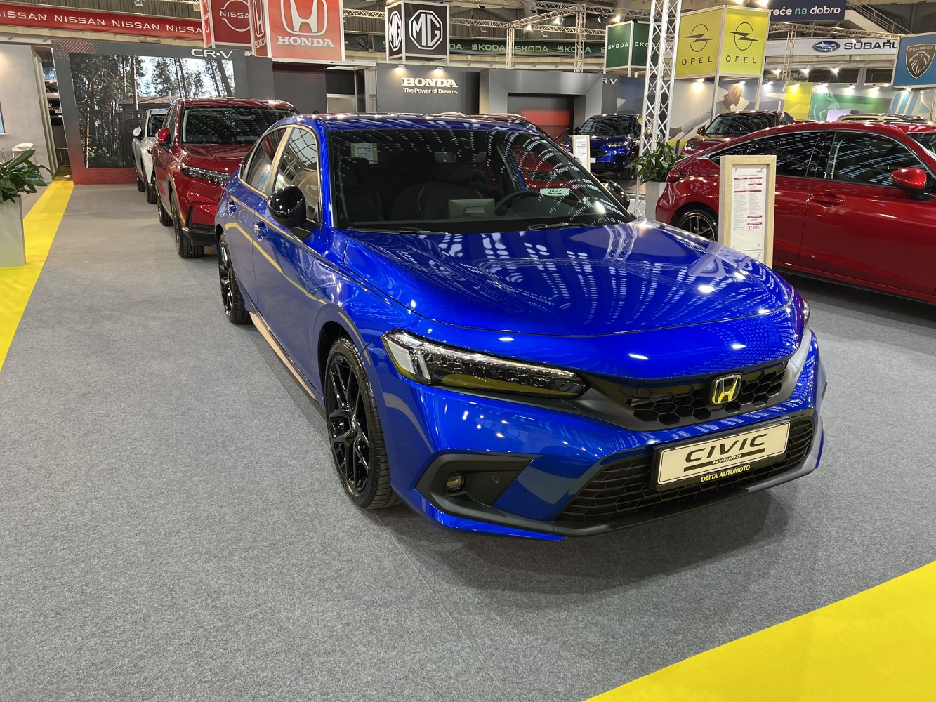Sporty blue sedan front-side view with LED headlights and black wheels