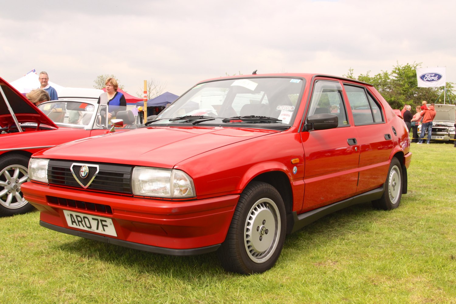 Red classic hatchback with Alfa Romeo grille and alloy wheels